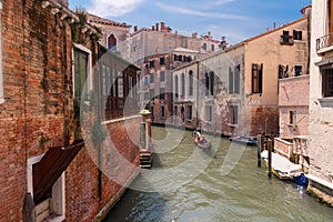 VENICE, ITALY Ã¢â¬â MAY 23, 2017: Traditional narrow canal street with gondolas and old houses in Venice, Italy.